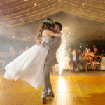 Novios abrazados celebrando su boda en un jardin de Morelos. Al fondo espectáculo de fuegos artificiales.