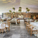 Imagen panorámica de un salón para fiestas semiabierto con mobiliario y decoración