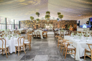 Imagen panorámica de un salón para fiestas semiabierto con mobiliario y decoración